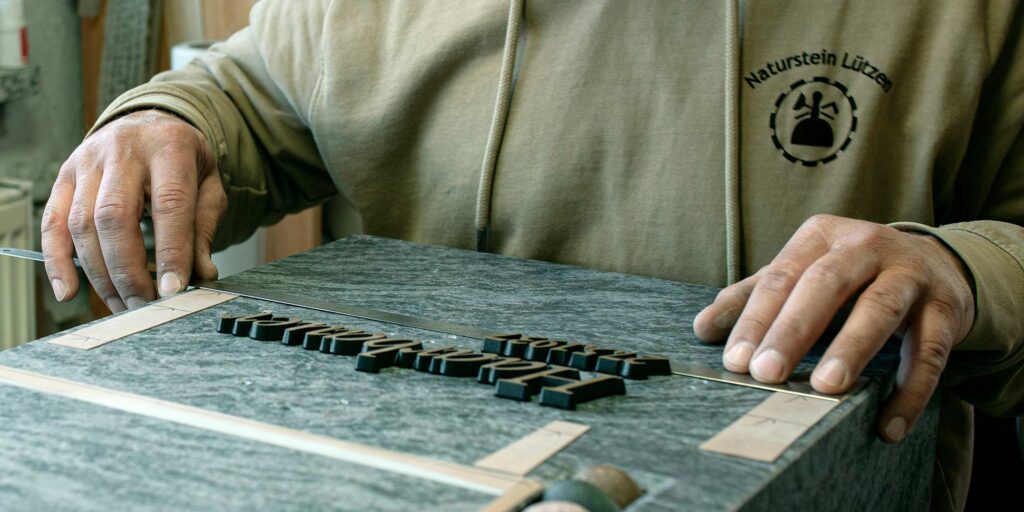 Bronze Buchstaben auf Grabmal
